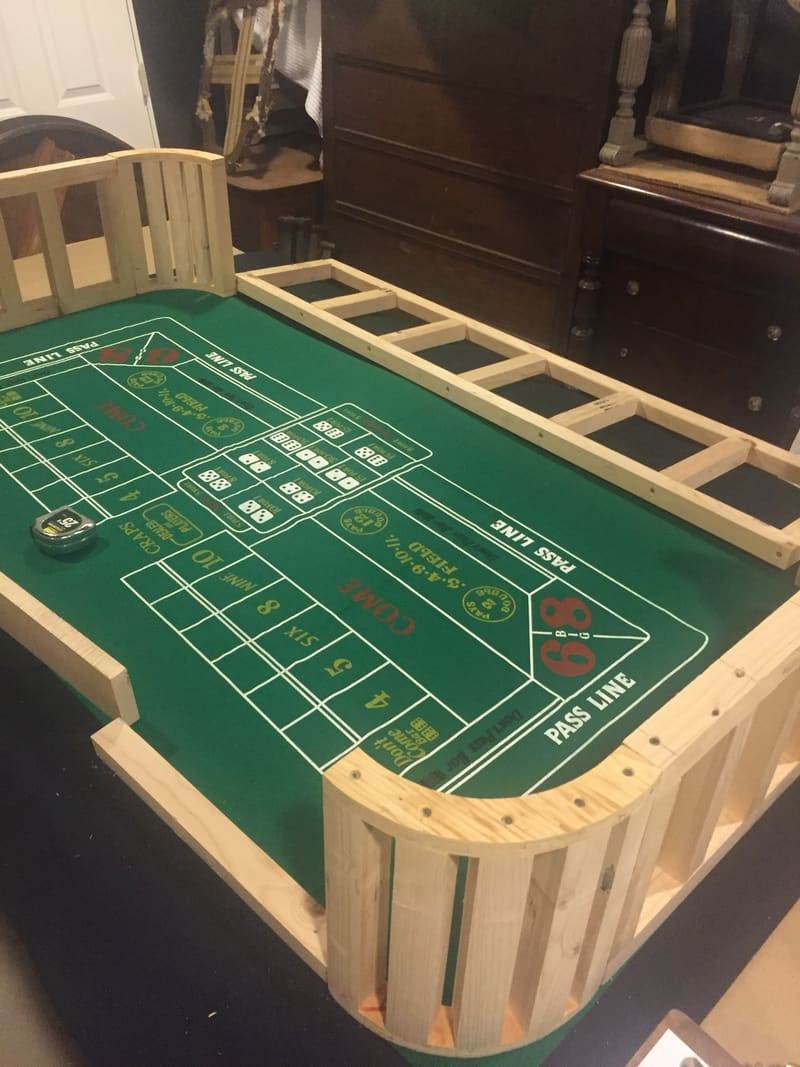 A custom game table with a green felt layout and a wood rail