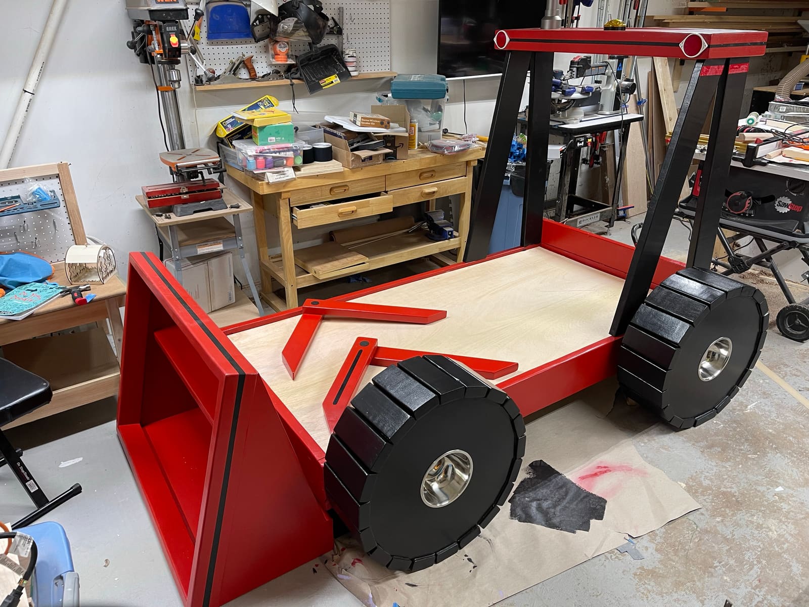 The same custom tractor bed painted red and black with black wheels
