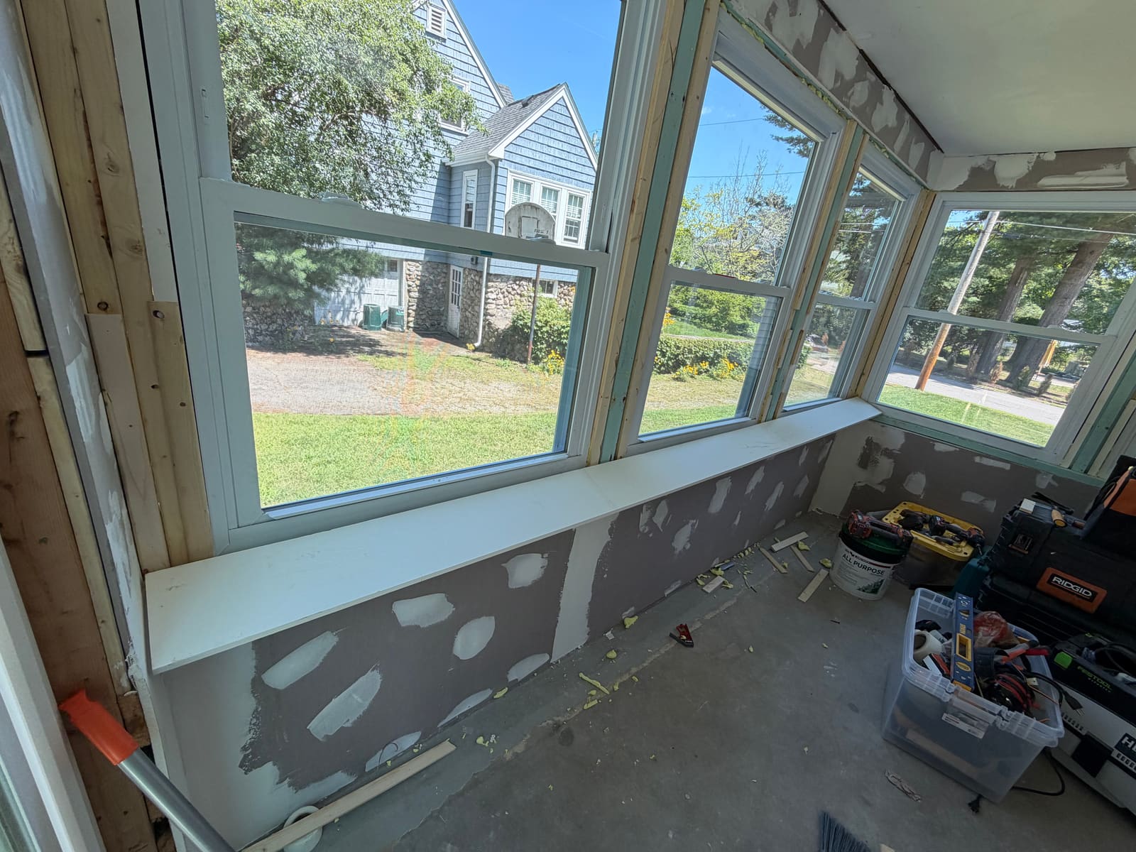 Drywall with patched and skim-coated sections beside new trim during a repair