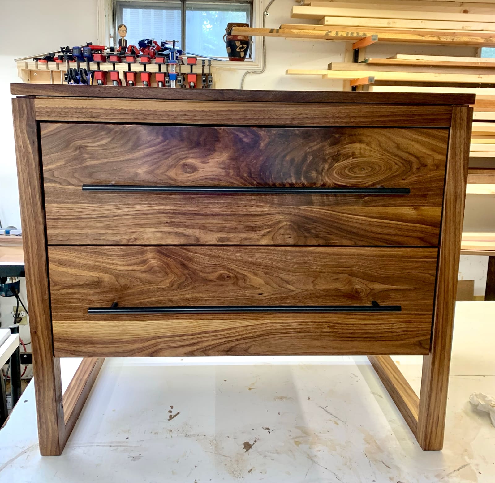 A walnut dresser with two drawers and black bar pulls built in my shop